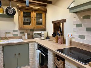 a kitchen with a counter with a sink and a microwave at Rock View Cottage, 2 bedrooms near Alton Towers in Alton