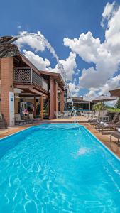 a large swimming pool in front of a house at Pousada do Lago in Brotas