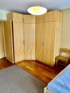 una camera da letto con armadi in legno, un letto e una lampada di Comfortable Stay in Siauliai a Šiauliai