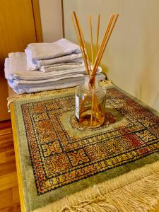 a vase with sticks in it sitting on a rug at Comfortable Stay in Siauliai in Šiauliai