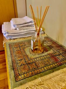 a vase with sticks in it sitting on a rug at Comfortable Stay in Siauliai in Šiauliai +7 photos