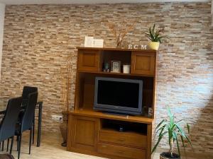 a living room with a television on a wooden entertainment center at Apartamento El Capricho in Cudillero