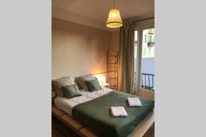 a bedroom with a bed with green sheets and a window at Garibaldi 3 chambres 6 couchages, EASY CHECK-IN in Nice