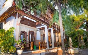 a house with palm trees in front of it at Bungalow No 7 in Nusa Lembongan