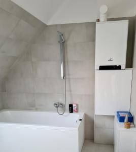 La salle de bains est pourvue d'une baignoire blanche et d'un lavabo. dans l'établissement P16 Apartment, à Hajdúböszörmény