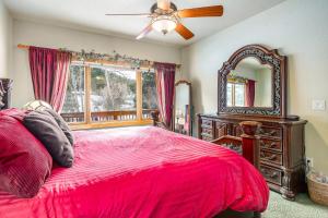 een slaapkamer met een rood bed en een spiegel bij Tranquility On The River Four -- EV #6041 townhouse in Estes Park