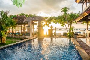 a swimming pool in a resort with the ocean in the background at Bungalow No 7 in Nusa Lembongan
