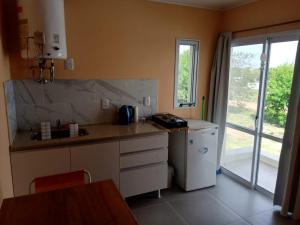a kitchen with a counter and a refrigerator and a window at Colon M in Colón