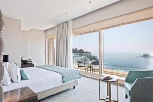 a bedroom with a bed and a large window at Hotel AMI Budva Petrovac in Petrovac na Moru
