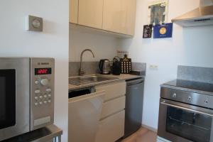 a kitchen with stainless steel appliances and a sink at Zeewende 18 in Zeebrugge