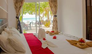a bedroom with a bed with a view of the beach at Crown Beach Hotel Maldives - Our Lobby is a Private Beach in Dhiffushi