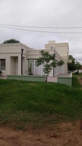 a white house with a tree in front of it at Colon M in Colón