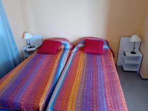 a bedroom with two beds with red pillows on them at Colon M in Colón
