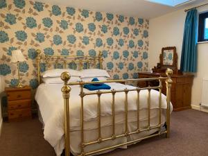 um quarto com uma cama com uma estrutura de cama dourada em Station House, Dartmoor and Coast located, Village centre Hotel em South Brent