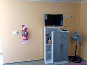 a room with a television on a wall with a cabinet at Colon M in Colón +7 photos