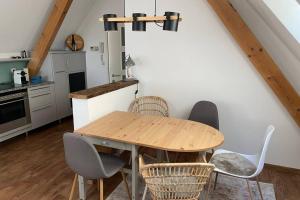 a kitchen with a wooden table and chairs at Deluxe Appartement über den Dächern von Krems in Krems an der Donau