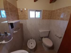 a bathroom with a toilet and a sink at CHOCHO - Cálida casita céntrica hasta 4 pax in San Carlos de Bariloche