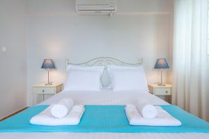 a bedroom with a white bed with towels on it at Meganisi Villas in Spartokhórion +63 photos
