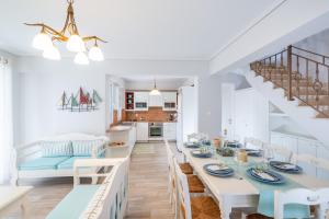a white dining room with a table and chairs at Meganisi Villas in Spartokhórion