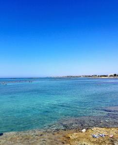 a large body of water with people swimming in it at Torre Ovo, Salento, casa in riva allo Jonio in Torre Ovo