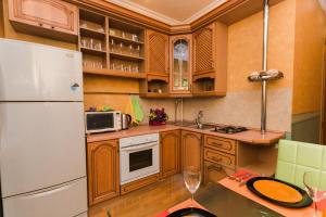 a kitchen with wooden cabinets and a white refrigerator at Tverskaya 17 in Moscow