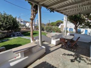 Agios RomanosにあるElia Apartmentsのパティオ(木製のテーブル、椅子、テーブル付)