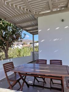 Agios RomanosにあるElia Apartmentsの木製テーブル、パティオ(椅子2脚付)