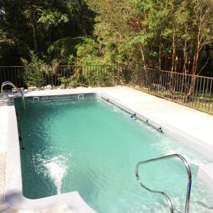 uma piscina com água azul e uma cerca em Huincaterra em Villarrica