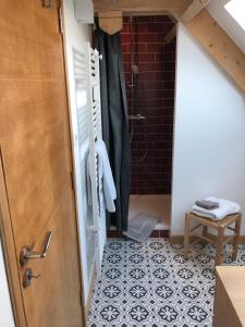 a bathroom with a shower and a tile floor at Touquet's Garden in Cucq