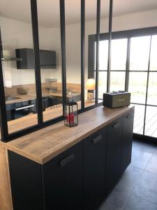 a kitchen with black cabinets and a counter with windows at Touquet's Garden in Cucq