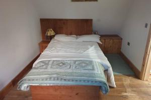 1 dormitorio con 1 cama grande y cabecero de madera en Traditional coach house in rural private estate. en Yeovil