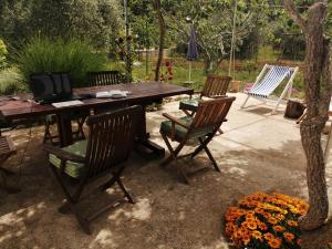uma mesa de madeira com cadeiras e uma televisão em Rustic House Miketa - Family Summertime em Lukoran