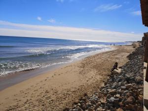 plaża z kamieniami i ocean w słoneczny dzień w obiekcie Villa Babilonia w mieście Guardamar del Segura
