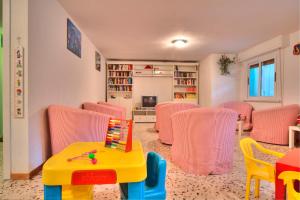 a living room with pink chairs and a table and a tablektop at Hotel Hamilton in Misano Adriatico