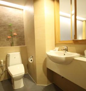 a bathroom with a white toilet and a sink at Windmill Resort Hotel Pattaya in Pattaya North