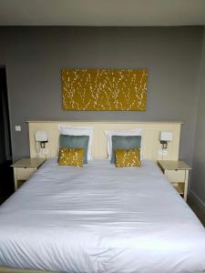 a large white bed with two pillows on it at Les Embruns in Trouville-sur-Mer