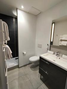 a white bathroom with a toilet and a sink at Les Embruns in Trouville-sur-Mer