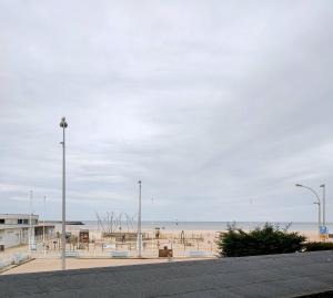 a beach with benches and a view of the ocean at Les Embruns in Trouville-sur-Mer