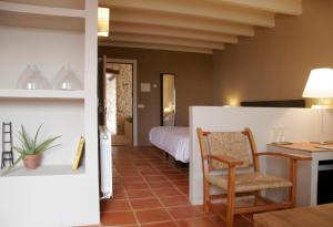a bedroom with a bed and a table and a chair at Aldea Roqueta Hotel Rural in Els Ibarsos