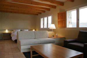 a living room with a couch and a bed at Aldea Roqueta Hotel Rural in Els Ibarsos