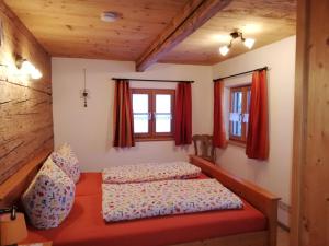 a bedroom with a bed and two windows at Ferienwohnung Grabenhäusl in Ruhpolding