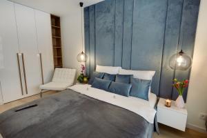 1 dormitorio con 1 cama grande y pared azul en Seven Heaven en Katowice