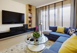 un soggiorno con divano blu e TV di Seven Heaven a Katowice