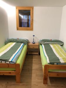 2 łóżka pojedyncze w pokoju z lustrem w obiekcie Haus Diezig w mieście Niederwald