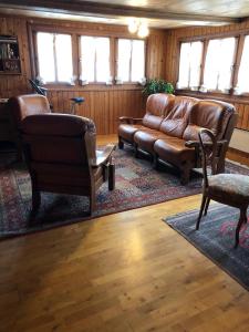 a living room with a leather couch and chairs at Haus Diezig in Niederwald