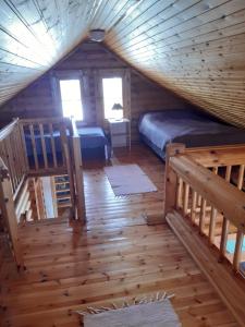a bedroom in a log cabin with two beds at Koivuranta in Pihtipuoas
