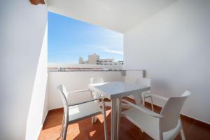 a white table and chairs in a room with a window at TC Apartamentos Dorotea in Playa del Ingles