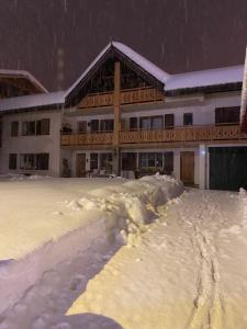 un edificio cubierto de nieve con mucha nieve en Résidences DELAVAY LA FERME, en Les Gets