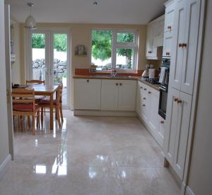 a kitchen with white cabinets and a table in it at 5 Ellesmere Avenue in Bundoran