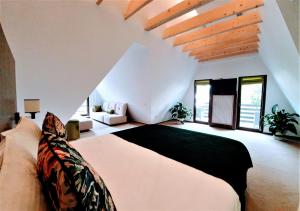 Casa Varful Cu Dor في سينيا: غرفة نوم بسرير كبير في غرفة بها نوافذ